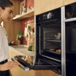 Neff Hide and Slide oven capacity - Lady opening the oven on the Neff Hide and Slide